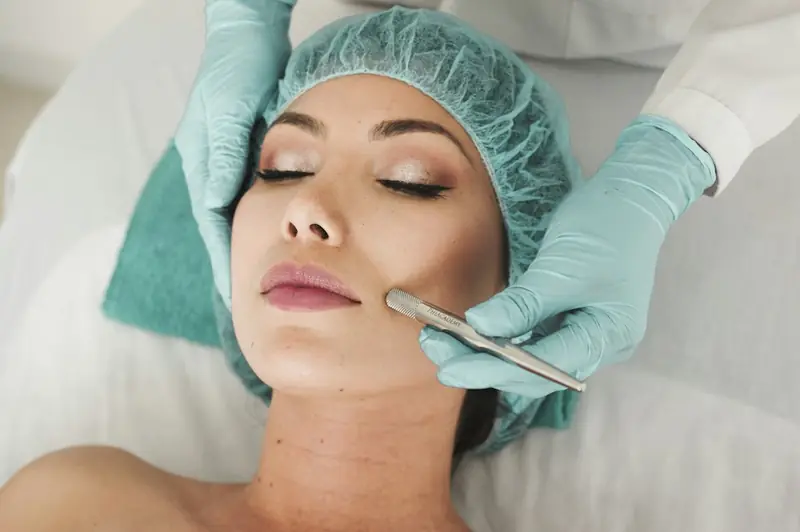 A clinician in gloves performing a facial skin treatment