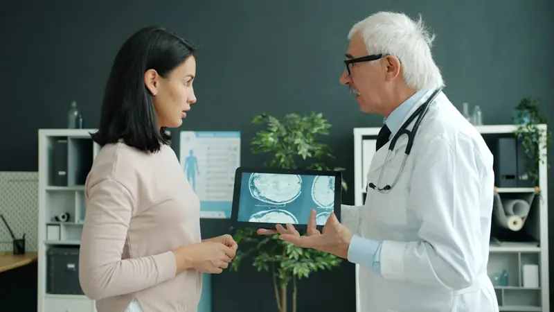 A doctor showing a patient her scan results on a tablet